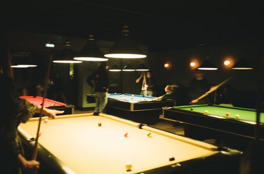 man in black jacket standing near billiard table