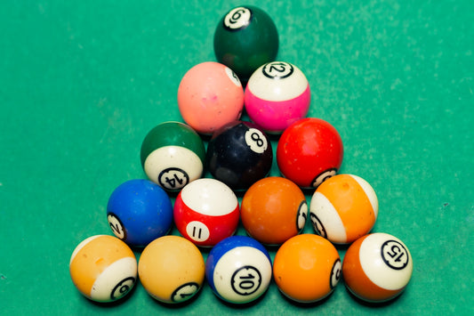 a pile of pool balls sitting on top of a green table