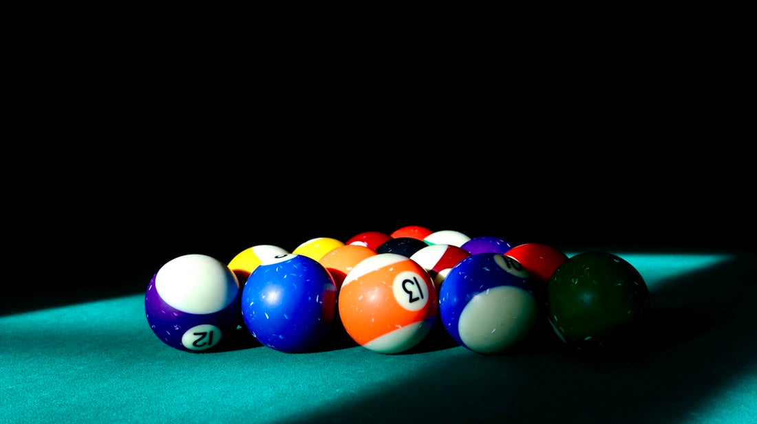 a row of pool balls sitting on top of a pool table