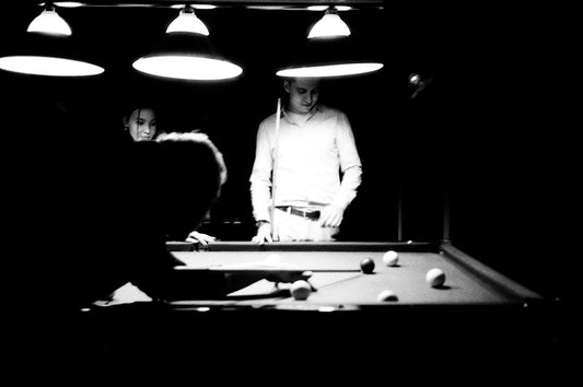 A man standing next to a pool table