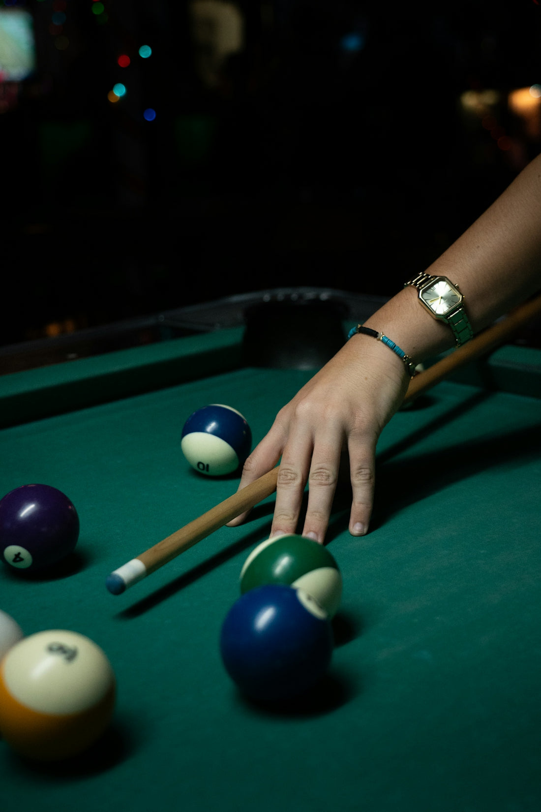 A person playing billiards on a green table.