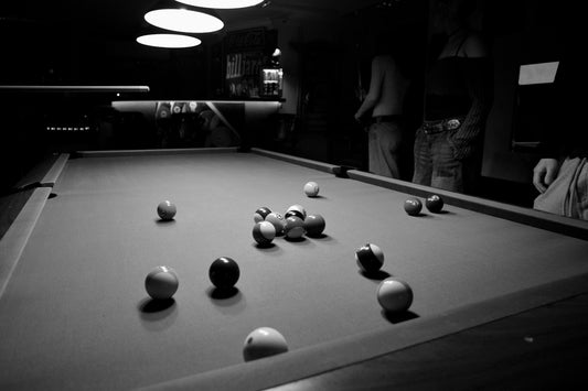 Black and white view of a pool table and balls.